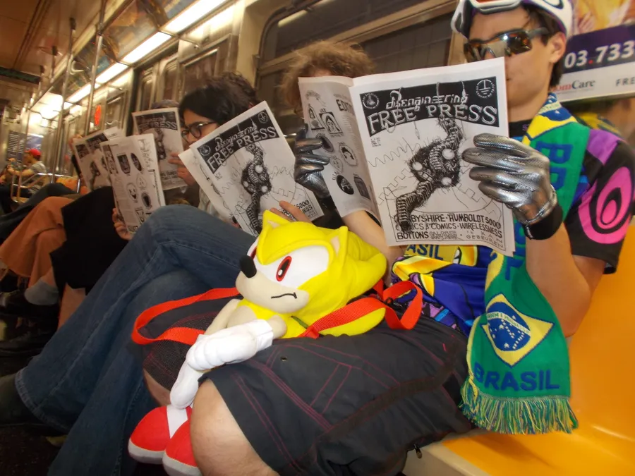People reading zines and newspapers at a gathering