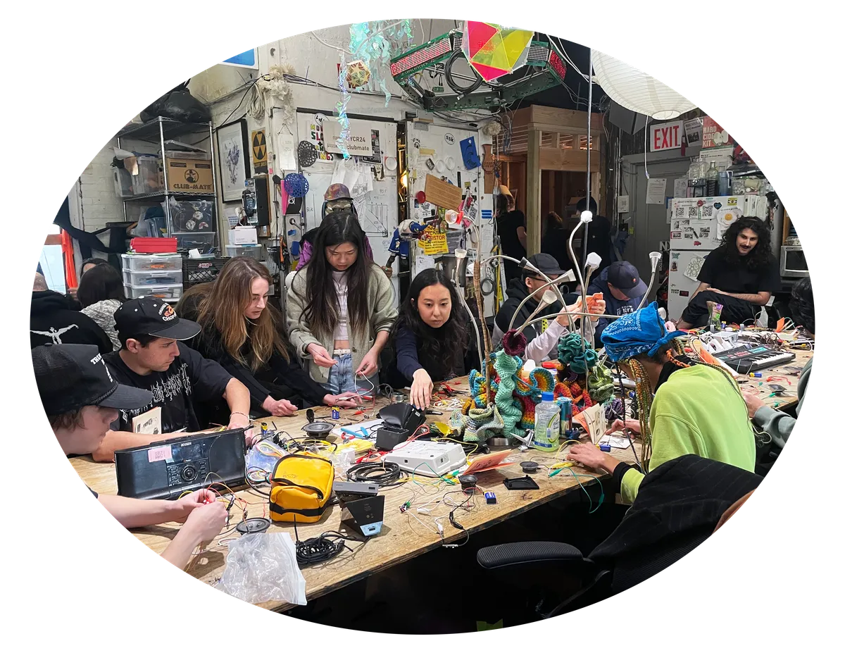 Workshop participants building electronics at a table