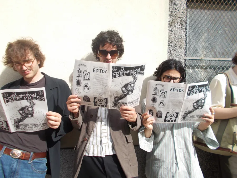 Readers sharing printed matter at a table